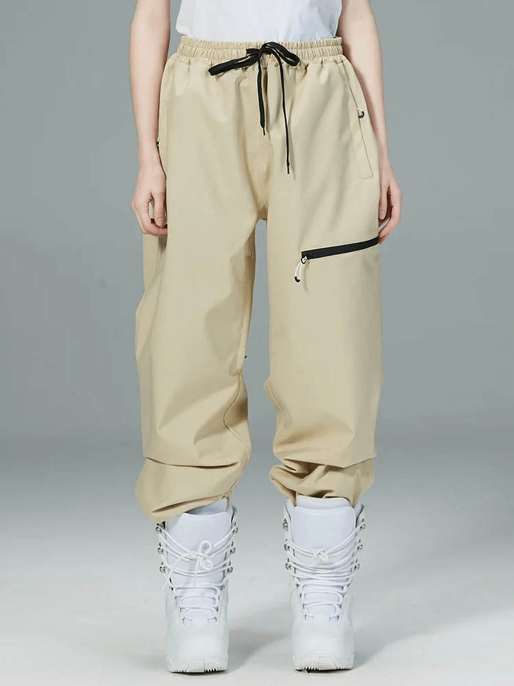 Unisex beige snowboarding pants with black drawstring and ankle boots, windproof and waterproof for outdoor winter sports.
